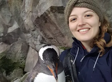 Jess smiling with her penguin friend