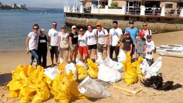 Group of people cleaning the beach with recycled bags